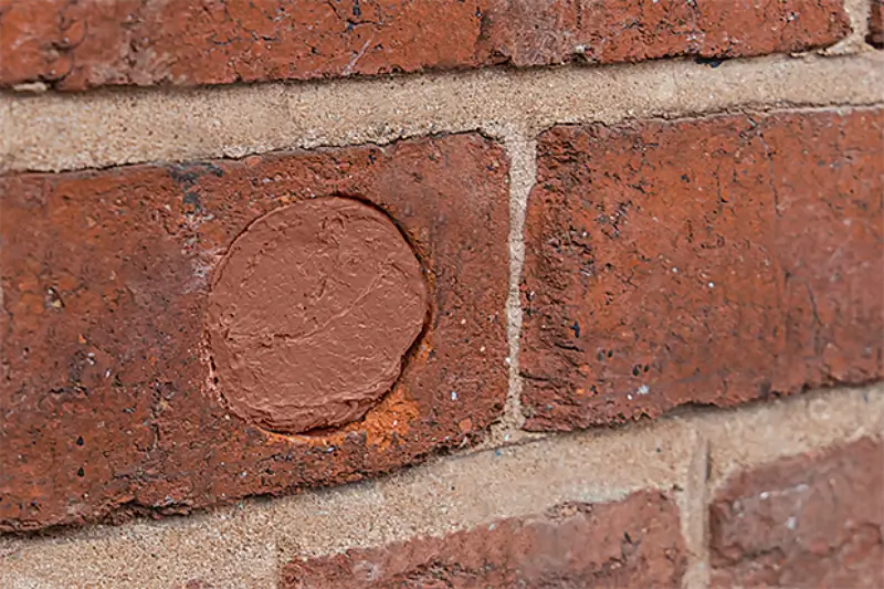 A brick wall with a hole filled using Flexi Armour seal.