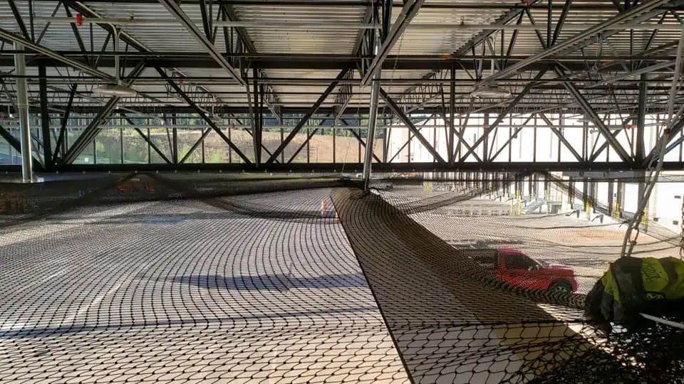 Bird netting being applied in a large commercial space