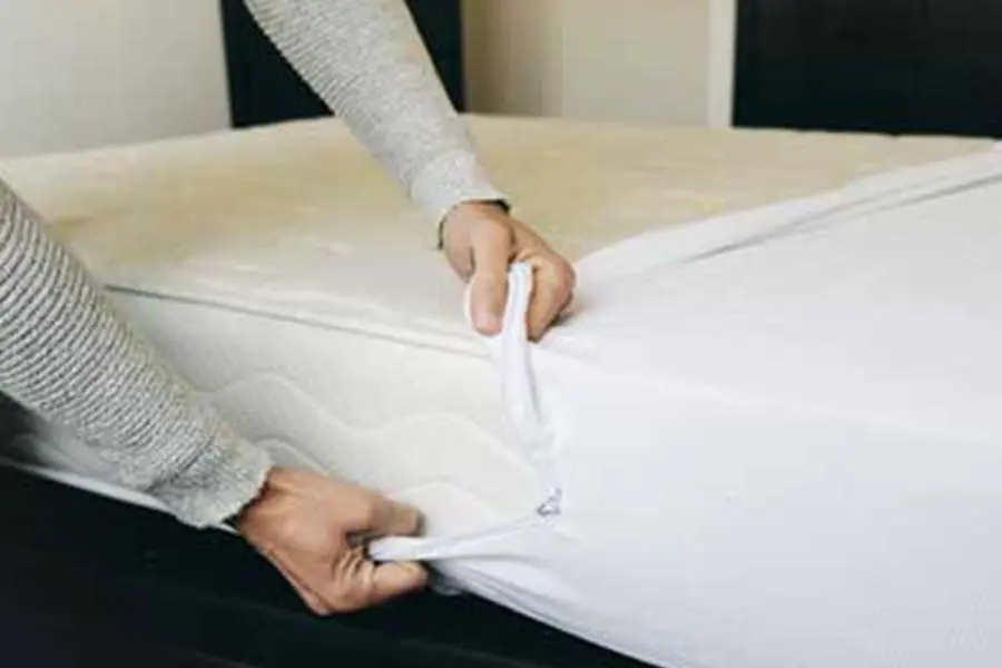 Hands pulling on a mattress cover