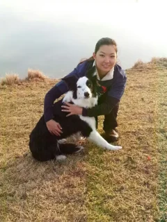 Person with Border collie at the edge of a pond