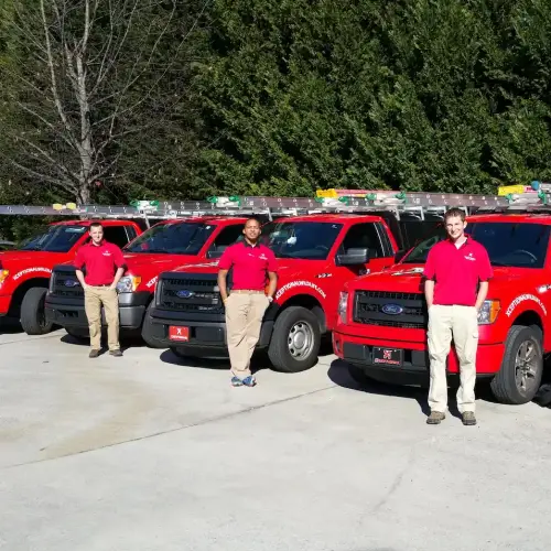 Xceptional Wildlife Removal technicians standing in front of service trucks before performing wildlife removal services