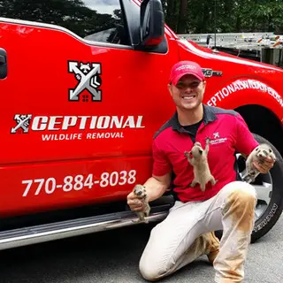 Xceptional Wildlife Removal tech posing by truck